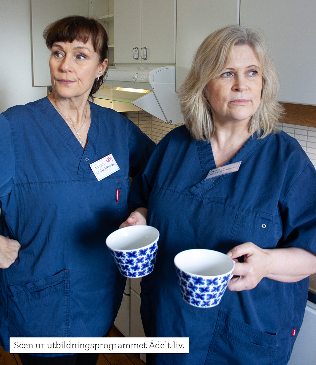 Scen ur utbildningdsprogrammet Ädelt liv. Vårdpersonalen Anna och Eva har dålig stämning i köket. Eva är sur och Anna tittar bort.